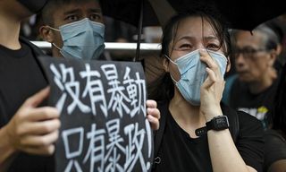 A protester holds a placard that reads: "No thug, only tyranny" as other chants slogans as they gather outside the Eastern Court in Hong Kong, Wednesday, July 31, 2019. (Image: Keystone)