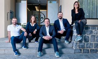 Bank Frick CFO Melanie Gstöhl (2nd from left) and CEO Edi Wögerer (center) presenting the new dress code and the corporate trainer together with employees. 